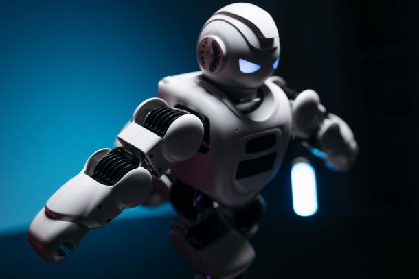 Close-up shot of tech white toy robot on blue background